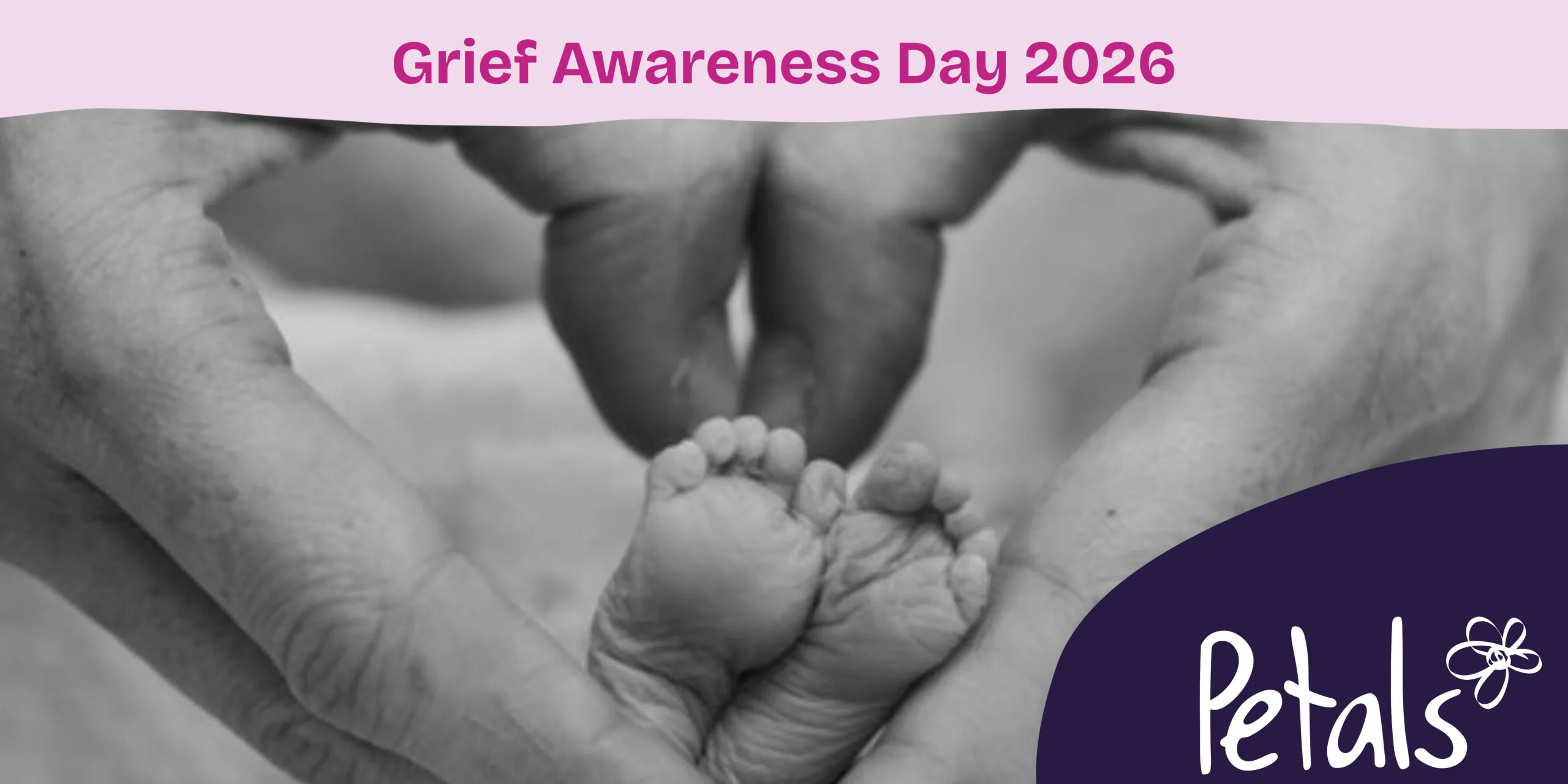A black and white photo of hands making a heart shape around baby's feet