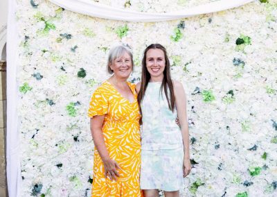 Petals anniversary guests in front of petal wall