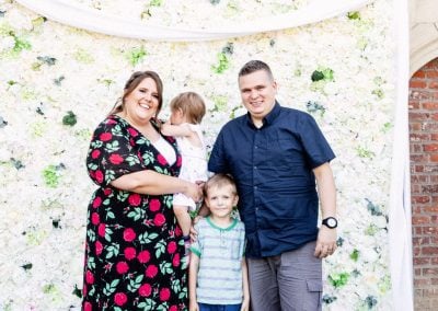 Family in front of flower wall